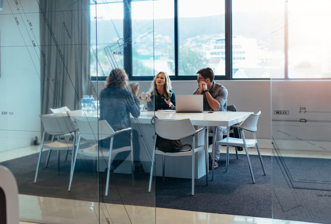 three people at a table in a conference room